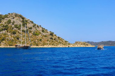 August 10, 2022 Demre, Antalya province, Turkey. Yachts near the Turkish rocky shore. Background with copy space for text