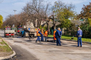 Road workers are repairing the road. Background with selective focus as copy space for text. October 25, 2022 Balti Moldova.