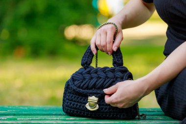 Wicker or knitted women's handbag close-up with selective focus on a blurred background