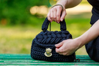Wicker or knitted women's handbag close-up with selective focus on a blurred background