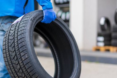 November 2, 2022 Balti Moldova. Tire in the worker's hand. Focus on the tire. Illustrative editorial, background