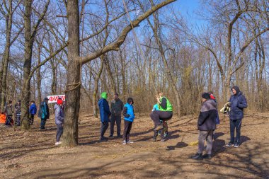 March 27, 2022 Mindrestii Moldova. Tourists lovers in the forest ride a rope. News editorial background