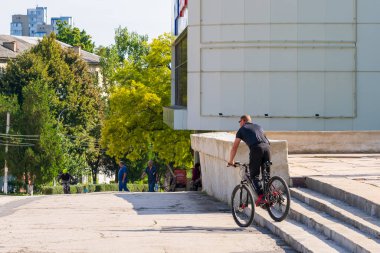 4 Eylül 2022 Balti Moldova. Sokak merdivenlerindeki bisikletçi. Şehirde amatör bisikletçilerin toplu toplantısı var. Resimli yazı, arka plan.