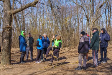 March 27, 2022 Mindrestii Moldova. Tourists lovers in the forest ride a rope. News editorial background