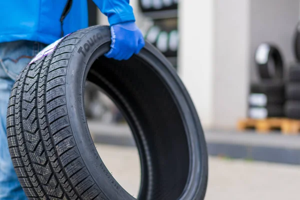 stock image November 2, 2022 Balti Moldova. Tire in the worker's hand. Focus on the tire. Illustrative editorial, background