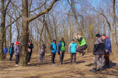 March 27, 2022 Mindrestii Moldova. Tourists lovers in the forest ride a rope. News editorial background