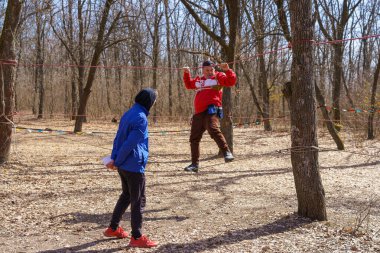 March 27, 2022 Mindrestii Moldova. Tourists amateurs train in the forest to walk on a rope. News editorial background