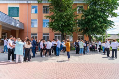 14 Haziran 2022 Balti Moldova. Öğrenciler sınavlardan sonra sonuçları bekliyorlar. Resimli editör arkaplanı