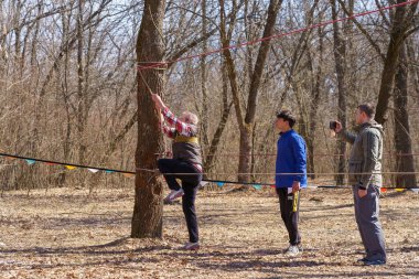 27 Mart 2022 Mindrestii Moldova. Amatör turistler şehrin dışındaki ormanda antrenman yapıyor. Haber başlığı arkaplanı