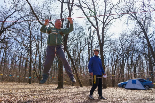 March 27, 2022 Mindrestii Moldova. Tourists amateurs train in the forest to walk on a rope. News editorial background