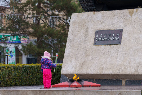 8 марта 2022 года Бельцы, Молдова. Иллюстративная редакция. Девушка возлагает цветы к памятнику с вечным огнем