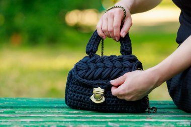 Wicker or knitted women's handbag close-up with selective focus on a blurred background
