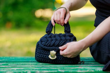 Wicker or knitted women's handbag close-up with selective focus on a blurred background
