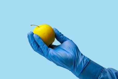 Doktorun elinde bir elma. Özenle seçilmiş bir arka plan. İzole edilmiş mavi tıbbi arkaplan