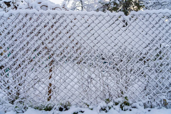 Wire fence in the snow. Winter background with selective focus