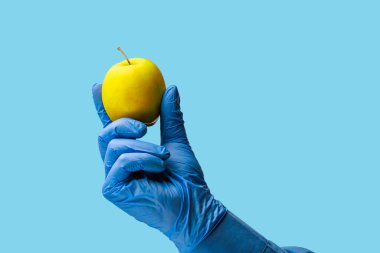 Doktorun elinde bir elma. Özenle seçilmiş bir arka plan. İzole edilmiş mavi tıbbi arkaplan