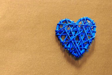 Tahta hasır kalp. Rattan, kalp şeklinde çalışır. Aşk konsepti. Seçici odaklı arkaplan ve boşluğu kopyala. Renkli folyoda.