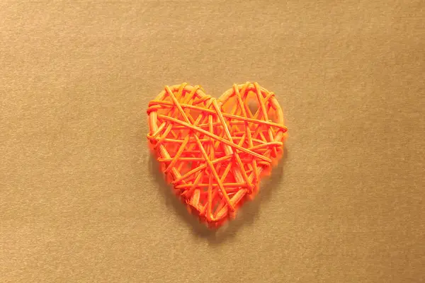 木制柳条的心脏 拉坦的工作是心形的 爱的概念 背景有选择的焦点和复制空间 在彩箔上 — 图库照片