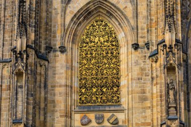 Altın pencere. Prag Kalesi 'ndeki Gotik Katolik Katedrali' nin, Wenceslas 'ın ve Vojtech' in dış görünüşünün ayrıntıları. Seçici odak ve kopyalama alanı olan arkaplan