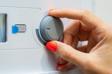 Parmaklar yeni bir kazanın termostatında. Seçici odaklı arkaplan ve metin için alanı kopyala