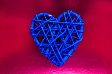 Tahta hasır kalp. Rattan, kalp şeklinde çalışır. Aşk konsepti. Seçici odaklı arkaplan ve boşluğu kopyala. Renkli folyoda.