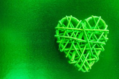 Tahta hasır kalp. Rattan, kalp şeklinde çalışır. Aşk konsepti. Seçici odaklı arkaplan ve boşluğu kopyala. Renkli folyoda.