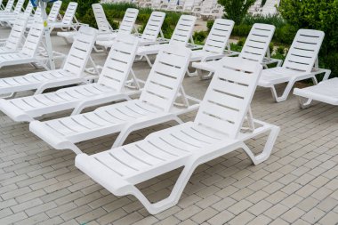 Havuzun yanındaki tatil köyünde boş güneş pansiyonları. Kopyalama alanı olan arkaplan