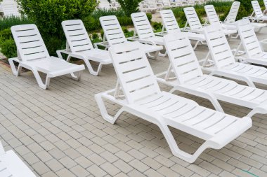 Havuzun yanındaki tatil köyünde boş güneş pansiyonları. Kopyalama alanı olan arkaplan