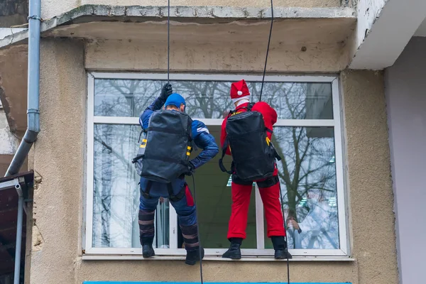 stock image December 27, 2022 Beltsy Moldova. Special forces in holiday costumes of superheroes climb a rope to congratulate children