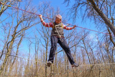 March 27, 2022 Mindrestii Moldova. Tourists amateurs train in the forest to walk on a rope. News editorial background