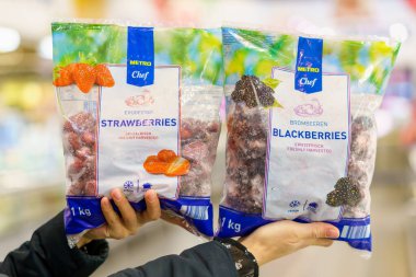 Bir pakette donmuş böğürtlen ve çilek. 2 Şubat 2023 Beltsy, Moldova. Resimli editoryal kullanım için.