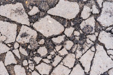Yolda çukurlar var ve asfalt parçalanmış. Metin için kopyalama alanı olan arkaplan