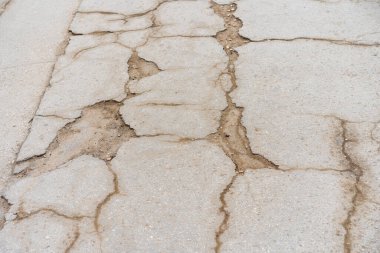 Yolda çukurlar var ve asfalt parçalanmış. Metin için kopyalama alanı olan arkaplan