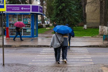 26 Mart 2023 Beltsy, Moldova. Resimli editör kullanımı için. Şemsiyeli insanlar