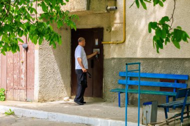 7 Haziran 2023 Beltsy, Moldova. Resimli editör kullanımı için. Dahili telefondan bir adam girişe giriyor.