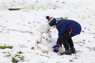 20 Kasım 2022 Beltsy, Moldova. Resimli editör kullanımı için. Çocuk kardan adam yapıyor.