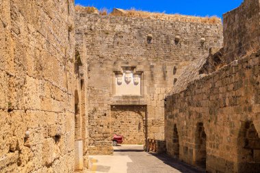 7 Ağustos 2023 Rodos Yunanistan. Resimli editör kullanımı için. Kalenin duvarında antik bir heykel var. Arkaplan