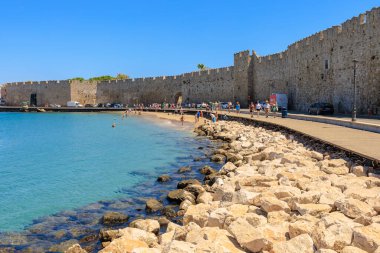 7 Ağustos 2023 Rodos Yunanistan. Resimli editör kullanımı için. Limanın yanındaki halk plajı, arka plan.