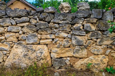 Havan topları olmadan toplanan taşlardan yapılmış eski bir çit. Seçici odak ve kopyalama alanı olan arkaplan