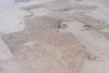 Yolda çukurlar var ve asfalt parçalanmış. Metin için kopyalama alanı olan arkaplan