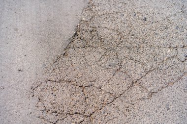 Yolda çukurlar var ve asfalt parçalanmış. Metin için kopyalama alanı olan arkaplan