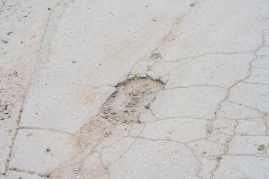 Yolda çukurlar var ve asfalt parçalanmış. Metin için kopyalama alanı olan arkaplan