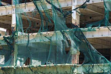 Kasırga rüzgarı tarafından yırtılan iskelelerde koruyucu ağ. Seçici odaklı arkaplan ve metin için alanı kopyala.