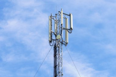 Mavi gökyüzü arka planlı telekomünikasyon kulesi. Teknoloji ve iletişim konsepti.