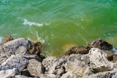 Taze bir rezervuarın kayalık kıyısı. Seçici odaklı arkaplan ve metin için alanı kopyala.