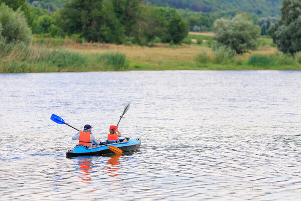 Люди путешествуют по реке на каяке. Рафтинг как здоровый образ жизни. Фон с копировальным пространством