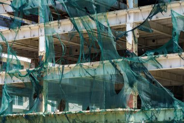 Kasırga rüzgarı tarafından yırtılan iskelelerde koruyucu ağ. Seçici odaklı arkaplan ve metin için alanı kopyala.