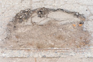 Yolda çukurlar var ve asfalt parçalanmış. Metin için kopyalama alanı olan arkaplan