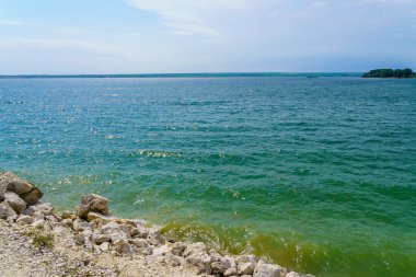 Taze bir rezervuarın kayalık kıyısı. Seçici odaklı arkaplan ve metin için alanı kopyala.
