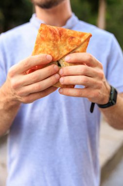 Pastaları tutan el kameraları, fast food konsepti. Seçici odaklı arkaplan ve metin için alanı kopyala